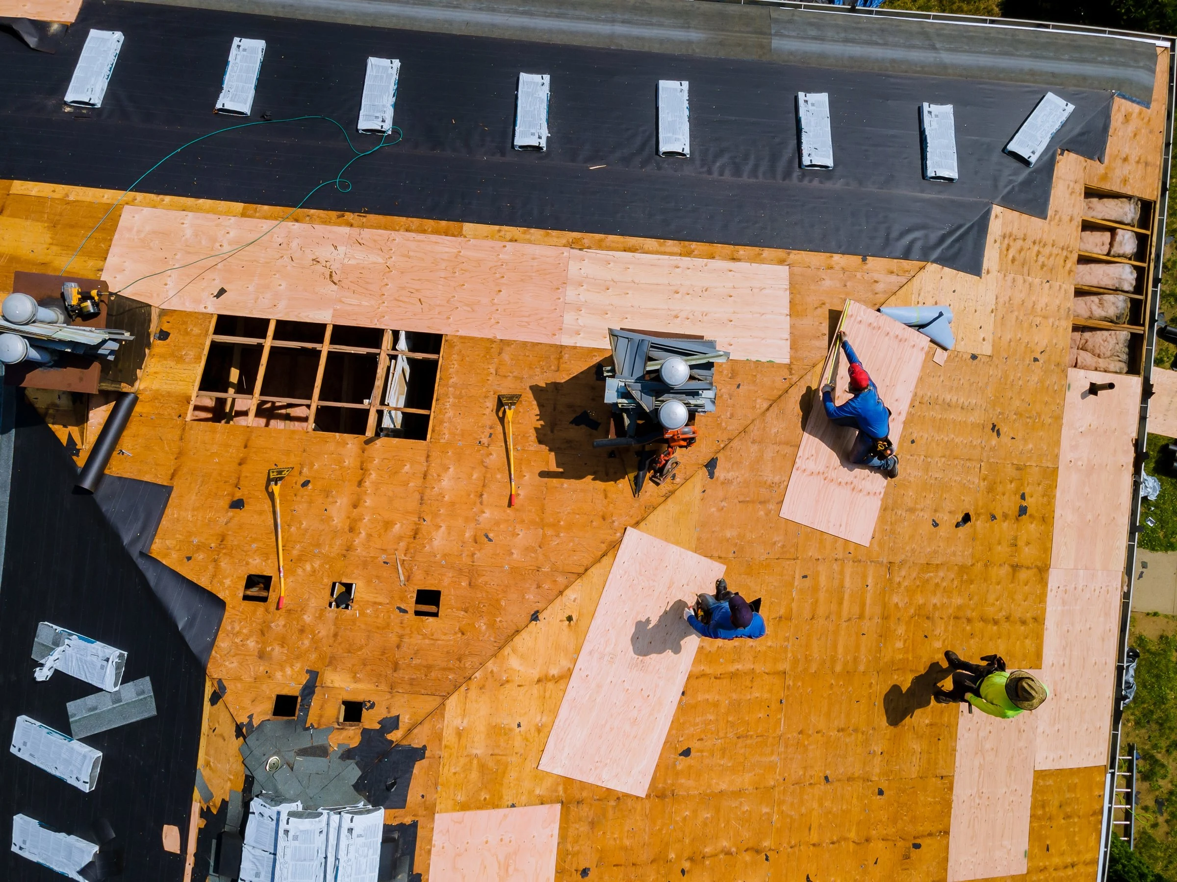 Aerial view of a roof tear-off with new decking going down